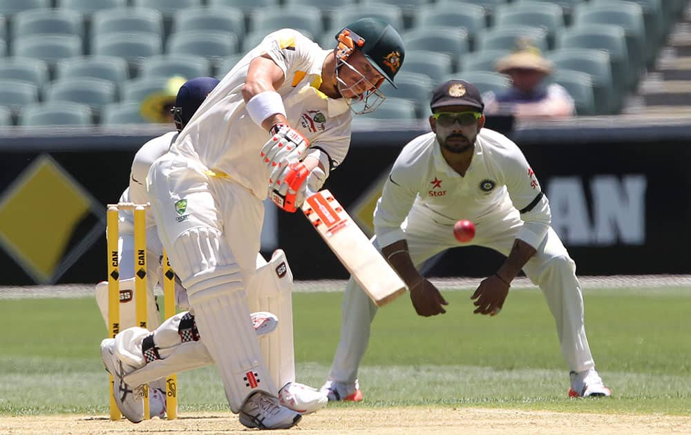 Australian batsman David Warner hits the ball during the first day of the first cricket test against India in Adelaide, Australia.