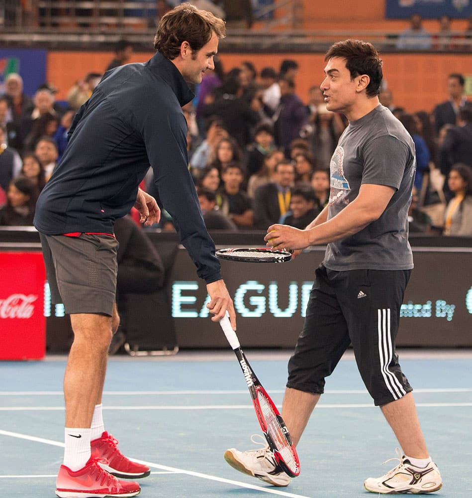 Bollywood actor Aamir Khan, right, shares a lighter moment with Roger Federer during a fun match in the sidelines of the International Premier Tennis League, in New Delhi.