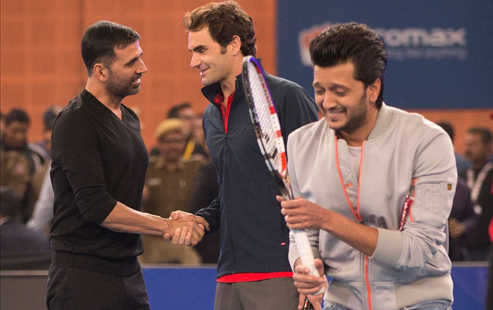 Micromax Indian Aces player Roger Federer, shakes hands with Indian Bollywood actor Akshay Kumar, left, as actor Ritesh Deshmukh passes by during a match on the sidelines of the International Premier Tennis League, in New Delhi.