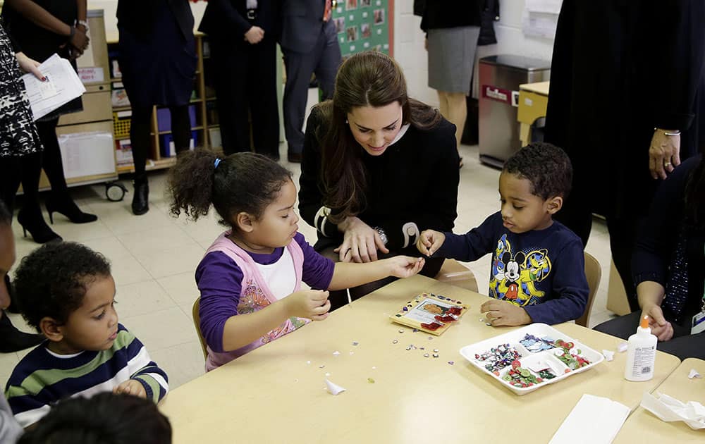 Kate, the Duchess of Cambridge, sits next to four-year-olds April, left, and Sammy in a pre-school class at the Northside Center for Childhood Development, in New York.