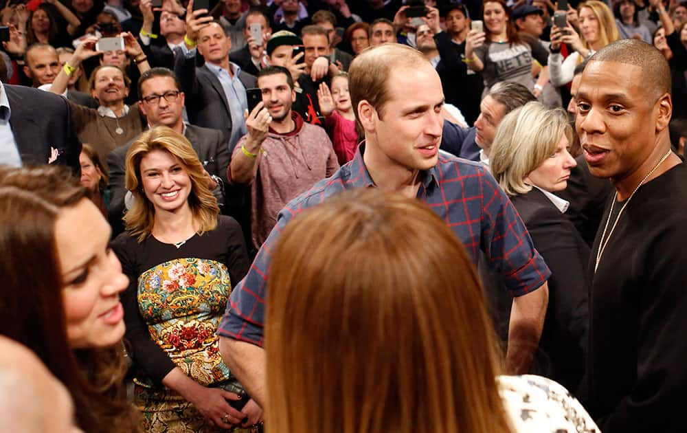 Britain's Prince William, second from right, talks with rapper and entrepreneur Jay-Z , far right, as Kate, left, the Duchess of Cambridge, chats with Jay Z's wife, entertainer Beyonce, foreground center, during an NBA basketball game between the Cleveland Cavaliers and the Brooklyn Nets at the Barclays Center in New York.