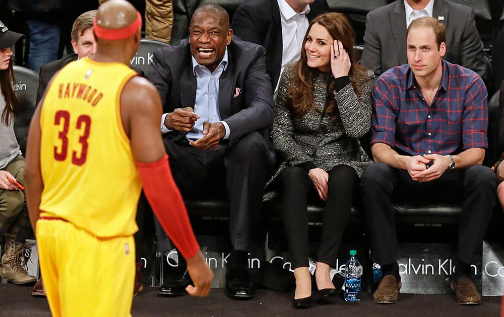 Britain's Prince William, right, and Kate, second from right, Duchess of Cambridge, watch former Houston Rockets player Dikembe Mutombo joke with Cleveland Cavaliers' Brendan Haywood, left, during the second half of an NBA basketball game against the Brooklyn Nets, in New York.