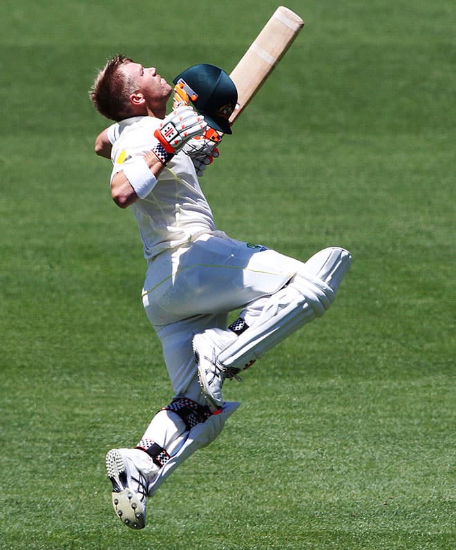 Australia's David Warner celebrates scoring a century during the first day of the cricket match in Adelaide, Australia.