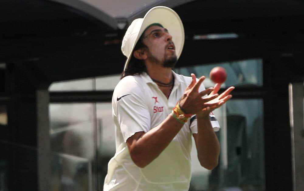 India's Ishant Sharma catches out Australia's David Warner during the first day of a cricket test match in Adelaide, Australia.