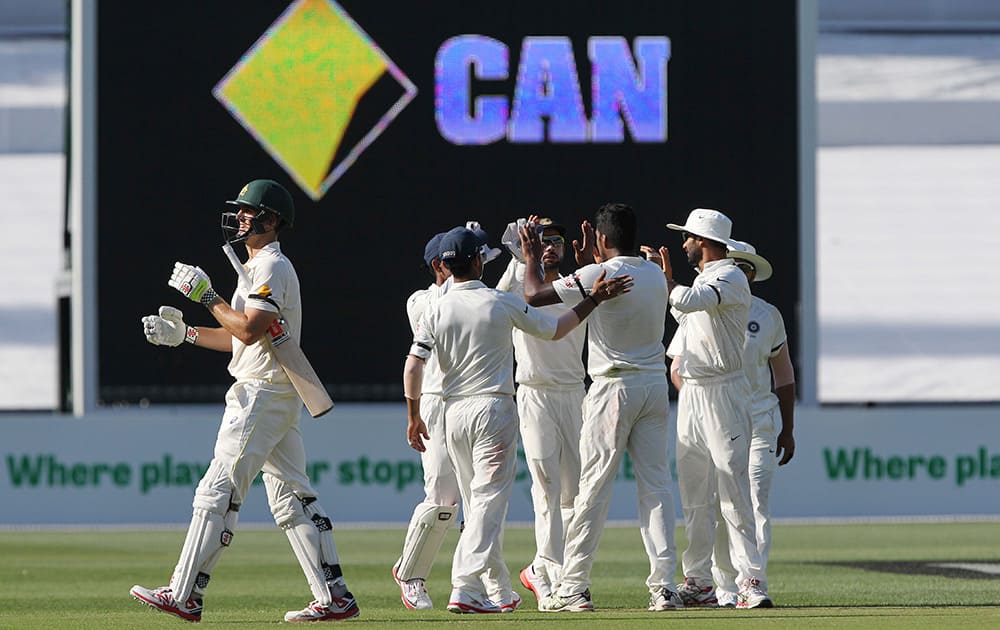 Indian players celebrate the wicket of Australia's Mitchel Marsh, left, during the first day of the cricket match in Adelaide, Australia.