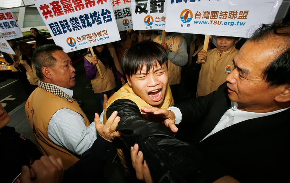 Opposition party supporters scuffle with police as they protest the arrival of Chen Deming, President of the Association for Relations Across the Taiwan Straits (ARATS), upon his arrival at the Taoyuan International Airport in Taoyuan, Taiwan.