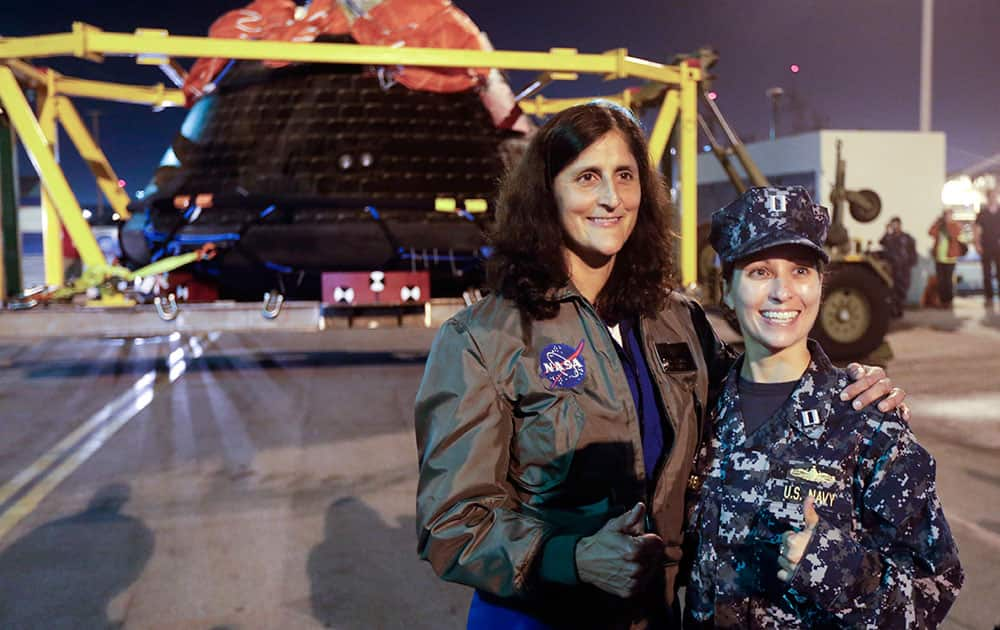 NASA astronaut Sunita Williams, second from right, poses for a picture with Navy Lt. Lydia von Gohren in front of the Orion space capsule in San Diego. NASA's new Orion spacecraft returned to dry land Monday in Southern California after a test flight that ended with a plunge in the Pacific Ocean.