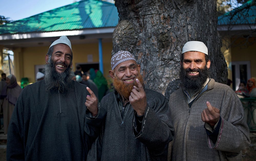 Kashmiri Muslim men show the ink mark on their index fingers after casting their votes during the third phase polling of the Jammu and Kashmir state elections in Monu, about 25 kilometers (15 miles) south west of Srinagar, Kashmir.
