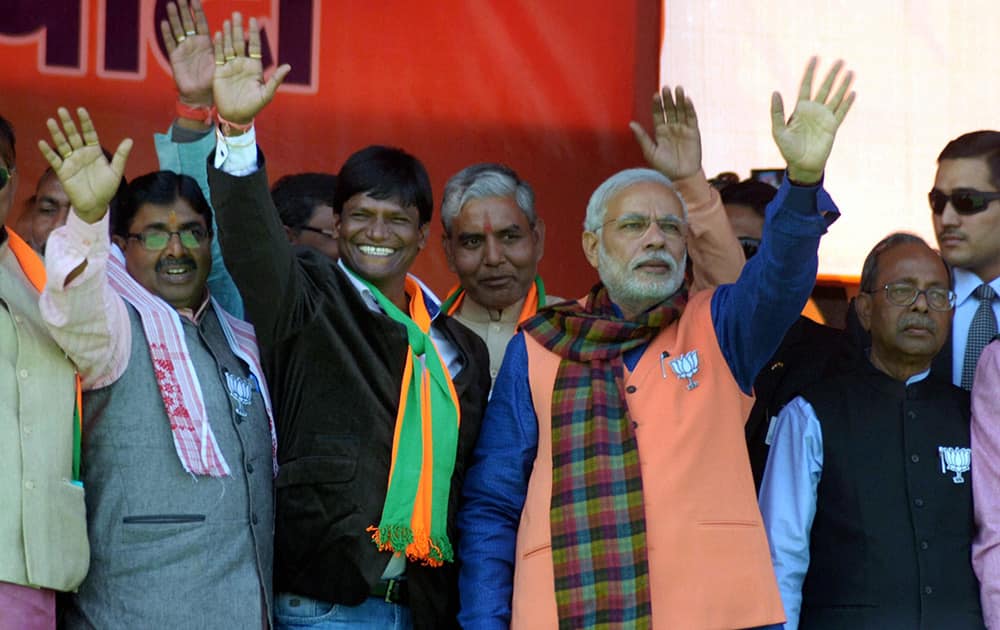 Prime Minister Narendra Modi waves to crowd at an election rally in support of NDA candidates in Dhandbad.