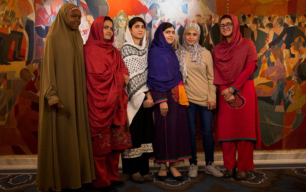 Joint Nobel Peace prize winner Malala Yousafzai, fourth left, stands with five young women she invited to attend the Nobel Peace Prize ceremony, from left, Nigeria's Amina Yusuf, Pakistan's Kainat Soomro, school friend Shazia Ramzan, Syria's Mezon Almellehan and school friend Kainat Riaz, as they pose for a group photograph before speaking to the media at Malala's hotel in Oslo, Norway.