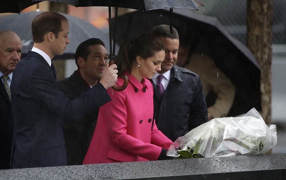 While Britain's Prince William, left, and Joe Daniels, president of the 9/11 Memorial, right, look on, as Kate, Duchess of Cambridge, lays flowers at the edge of a memorial pool at the National Sept.11 Memorial in New York.