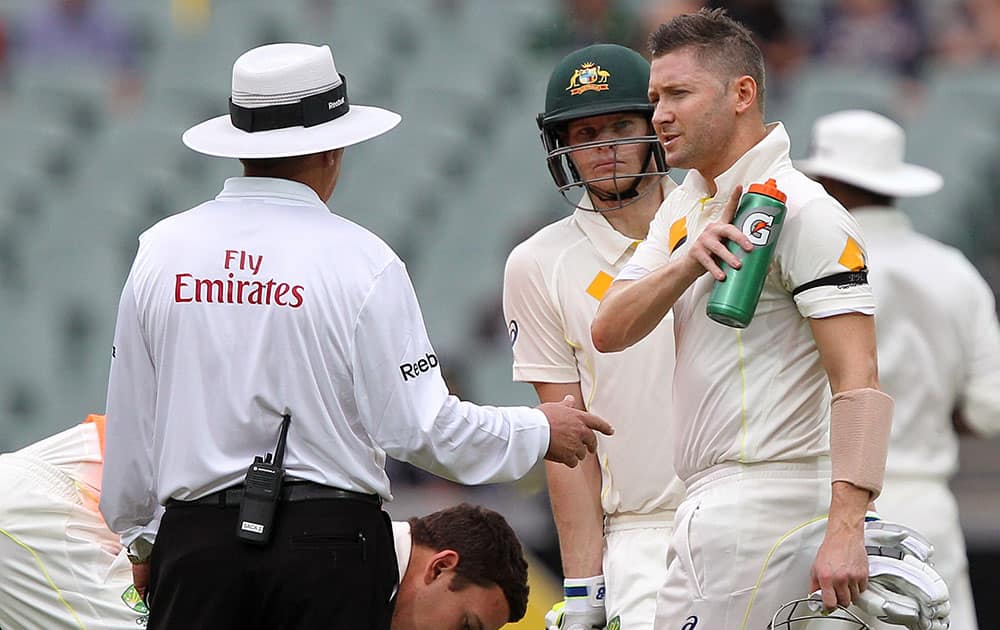 Australia's captain Michael Clarke, right, talks with umpire Ian Gould, of England, shortly before a rain delay during the second day of their cricket test match against India in Adelaide, Australia.