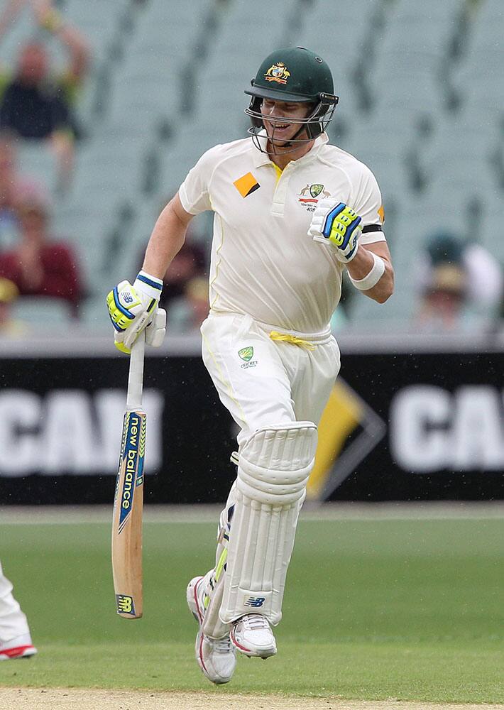 Australia's Steve Smith begins to celebrate making 100 runs during the second day of their cricket test match against India in Adelaide, Australia.