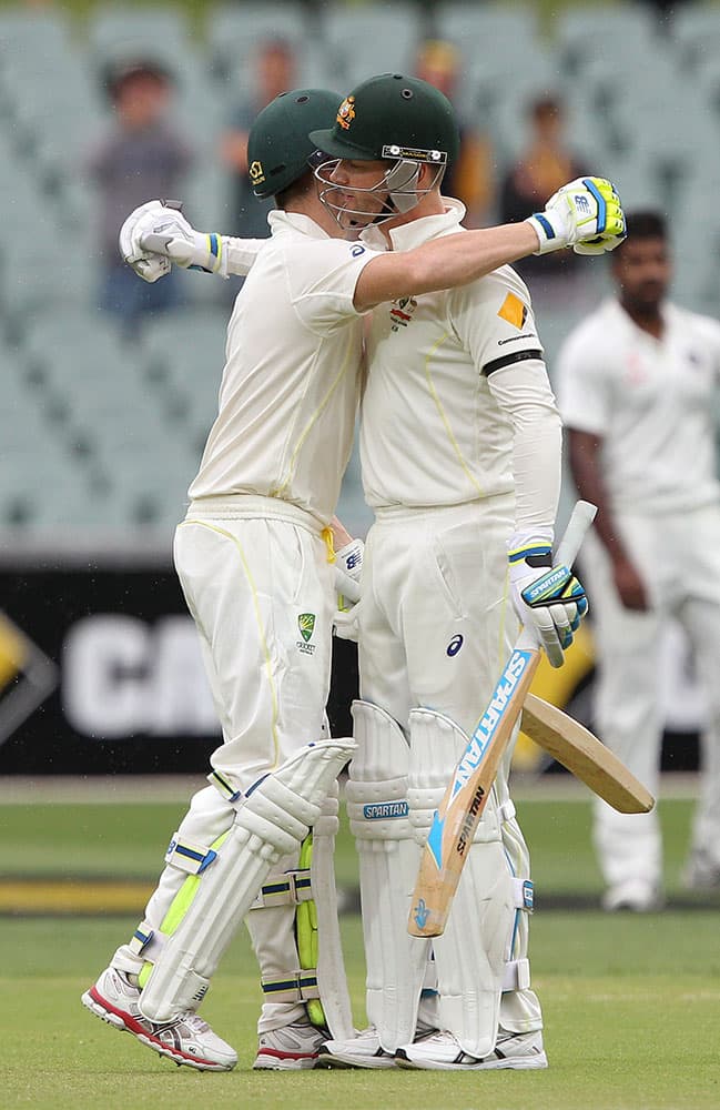 Australia's Steve Smith, left, is embraced by his captain Michael Clarke after Smith made 100 runs during the second day of their cricket test match against India in Adelaide, Australia.