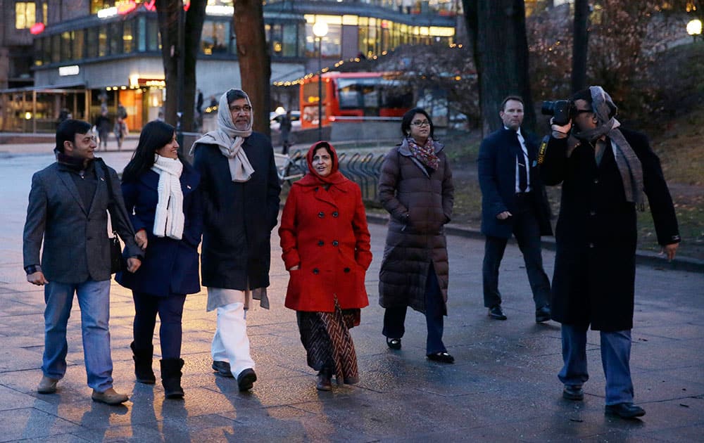 Joint-Nobel Peace Prize winner Indian children's rights activist Kailash Satyarthi, thid left, goes for a walk with family members and a security officer, second right, after arriving in Oslo, Norway.