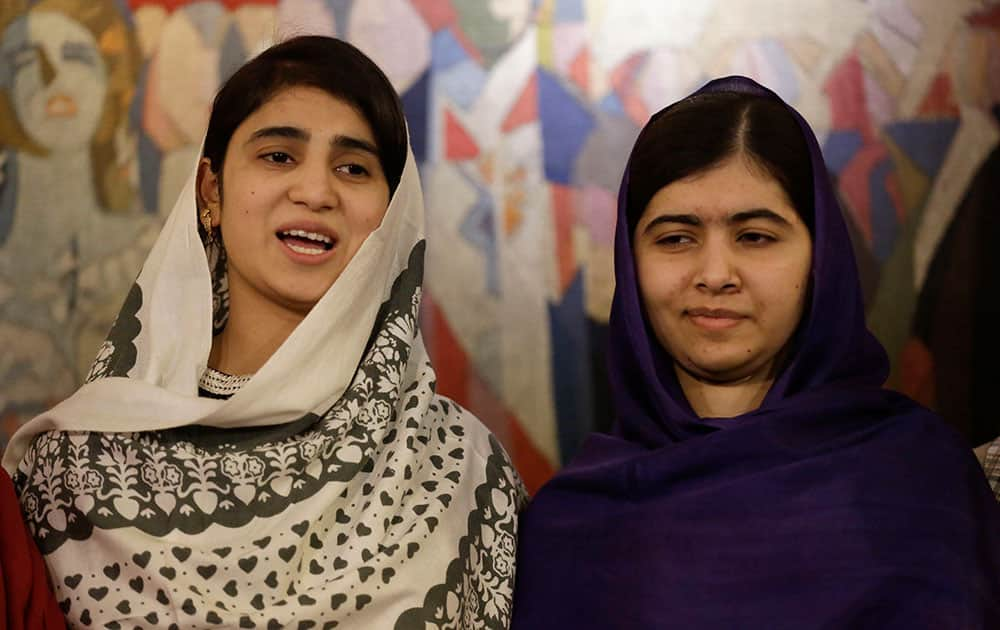 Joint Nobel Peace prize winner Malala Yousafzai, right, stands with one of the five young women she invited to attend the Nobel Peace Prize ceremony, her school friend Shazia Ramazan as they speak to the media at Malala's hotel in Oslo, Norway.