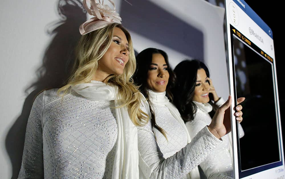 Moet & Chandon models Marion Vijar, left, Daniella Medina, center, and Alessia Anprade, right, pose for a photo during the 