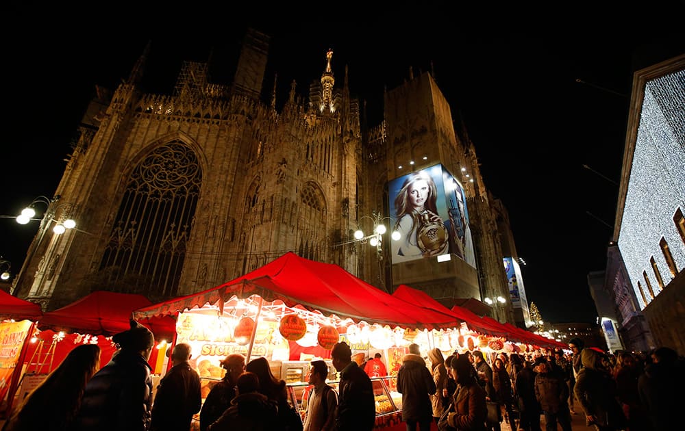 The Duomo gothic cathedral is seen behind a traditional open air Christmas market, in Milan, Italy.