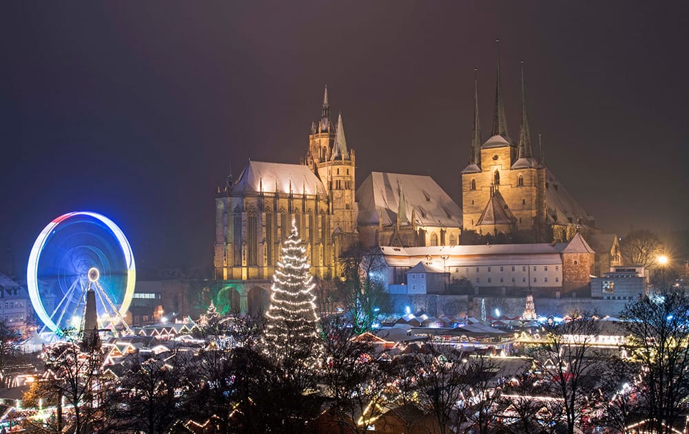 More than 200 booths offer traditional Thuringian handicrafts and sweets and a Ferris wheel stand on the Christmas Market in front of the Mariendom (Cathedral of Mary) and St. Severi's Church in Erfurt, central Germany.