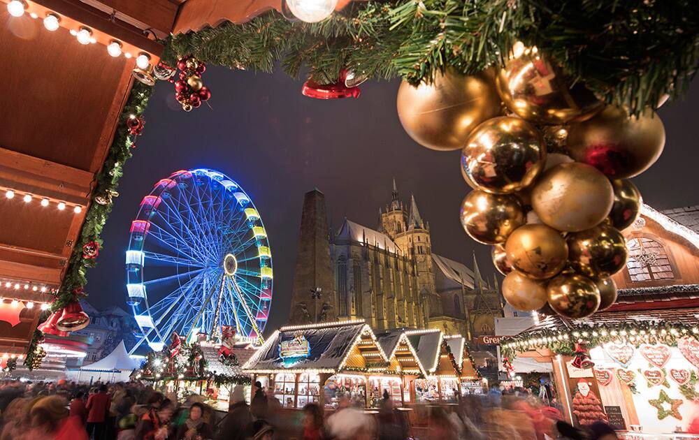 People walk along the Christmas market in front of the Mariendom (Cathedral of Mary) in Erfurt, central Germany. The Erfurt Christmas Market is one of the most beautiful Christmas Markets in Germany.