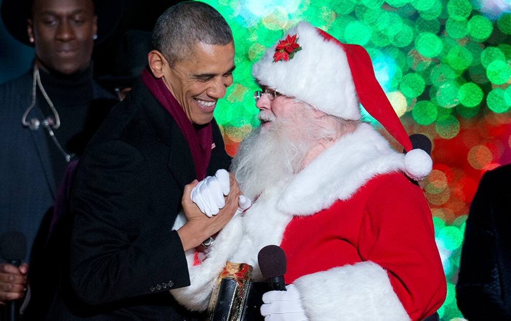 President Barack Obama greets Santa on stage during the National Christmas Tree lighting ceremony at the Ellipse near the White House in Washington.