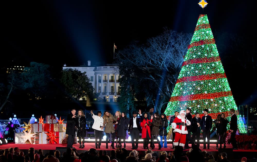 Performers gather on stage from left, Tom Hanks, Rita Wilson, Patti LaBelle, Fifth Harmony, Chely Wright, NE-YO, Nico & Vinz, The Tenors and Santa, during the finale of the National Christmas Tree lighting ceremony at the Ellipse near the White House in Washington.