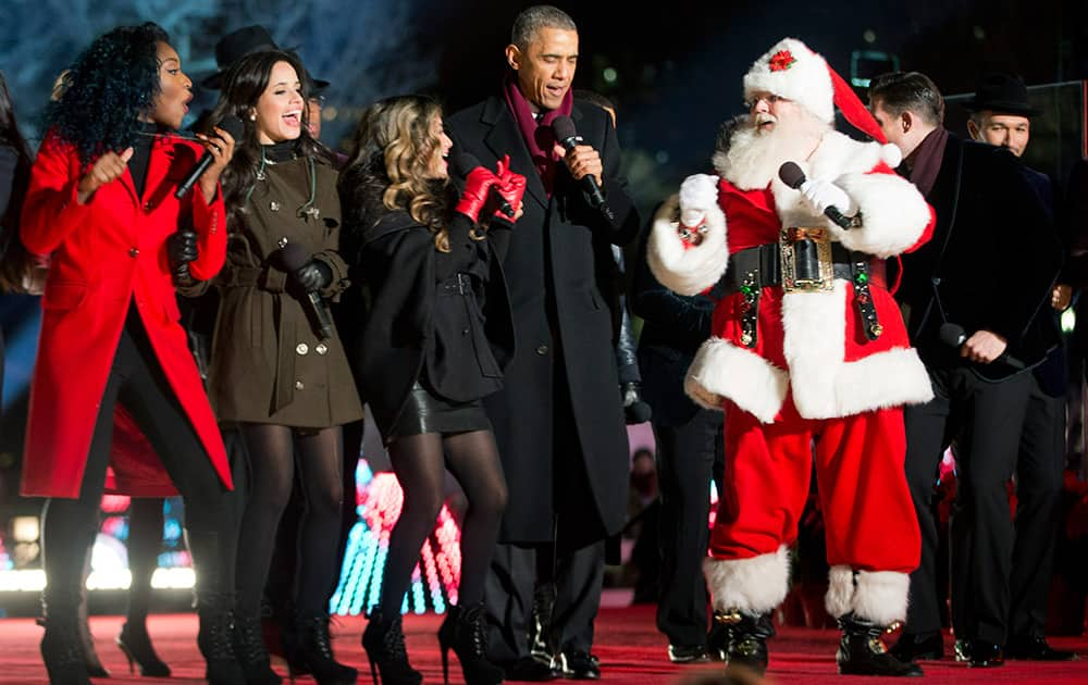 President Barack Obama, joins Santa Claus and other performers on stage during the finale at the National Christmas Tree lighting ceremony, on the Ellipse near the White House in Washington.