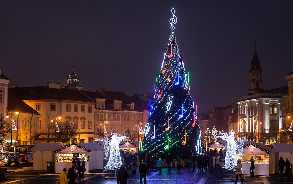 People stroll around a Christmas tree in the Old city in Vilnius, Lithuania.