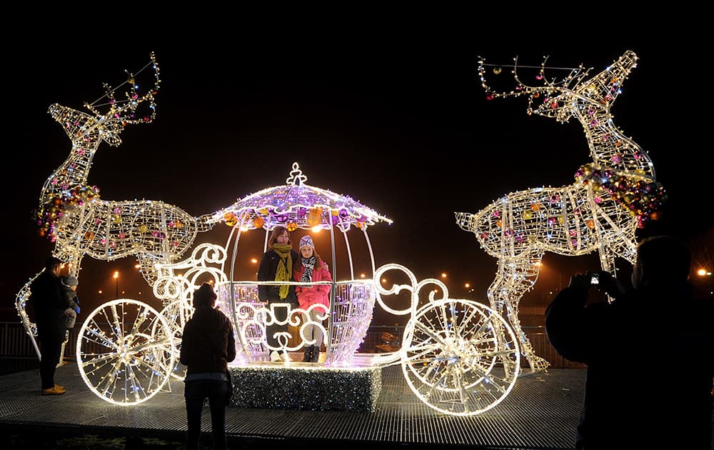 People have photos taken in a Christmas decoration on a street in Warsaw, Poland.