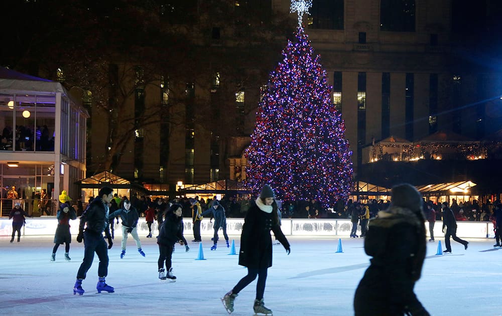 Skaters glide around the ice rink immediately after a Christmas tree lighting ceremony at Winter Village at Bryant Park, in New York.