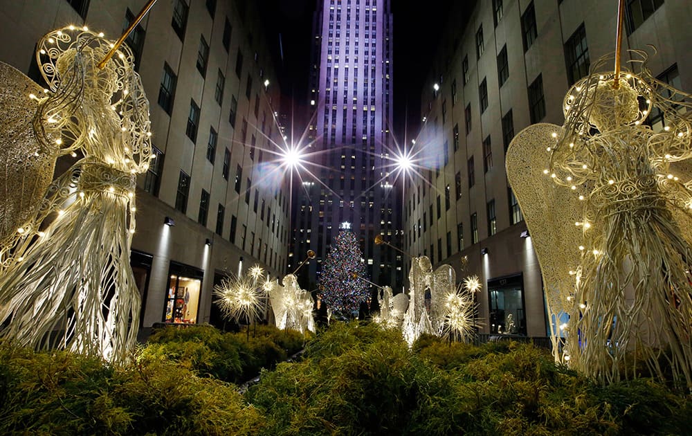 The Rockefeller Center Christmas tree can be seen through the Channel Gardens following a lighting ceremony, in New York.