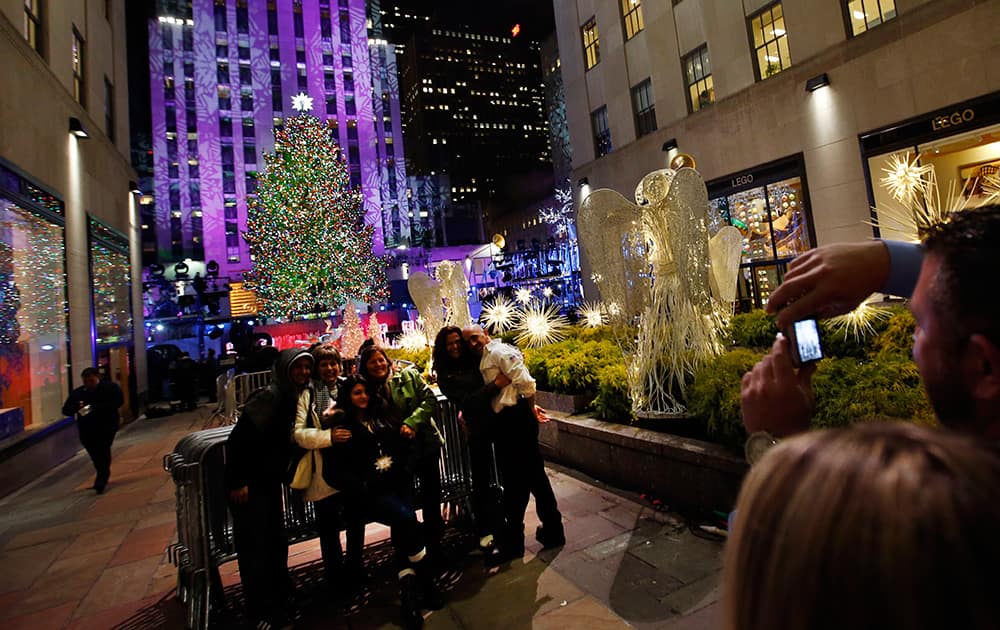 A group has their picture taken with the Rockefeller Center Christmas tree after it was lighted, in New York. 