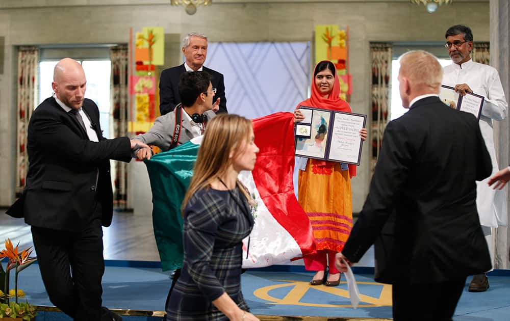 A man holding the Mexican flag is led away by security after attempting to get on stage with Nobel Peace Prize winners Malala Yousafzai from Pakistan and Kailash Satyarthi of India during the Nobel Peace Prize award ceremony in Oslo, Norway.