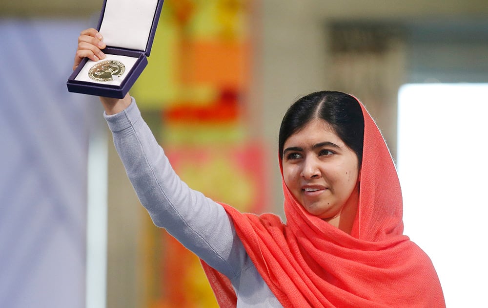 Nobel Peace Prize winners Malala Yousafzai from Pakistan holds up her medal during the Nobel Peace Prize award ceremony in Oslo, Norway.