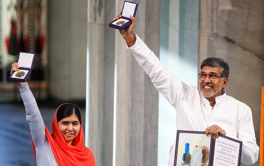 Nobel Peace Prize winners Malala Yousafzai from Pakistan and Kailash Satyarthi of India hold up their Nobel Peace Prize medals during the Nobel Peace Prize award ceremony in Oslo, Norway.