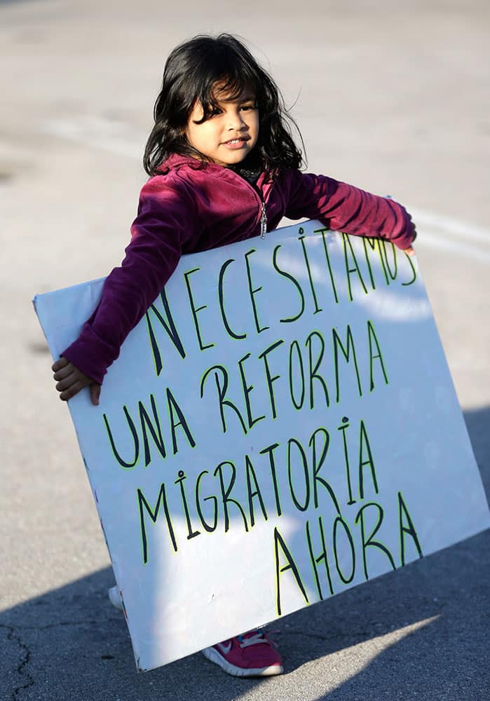 Nayleth Martinez, four-years-old, from Honduras, carries a sign that reads in Spanish 