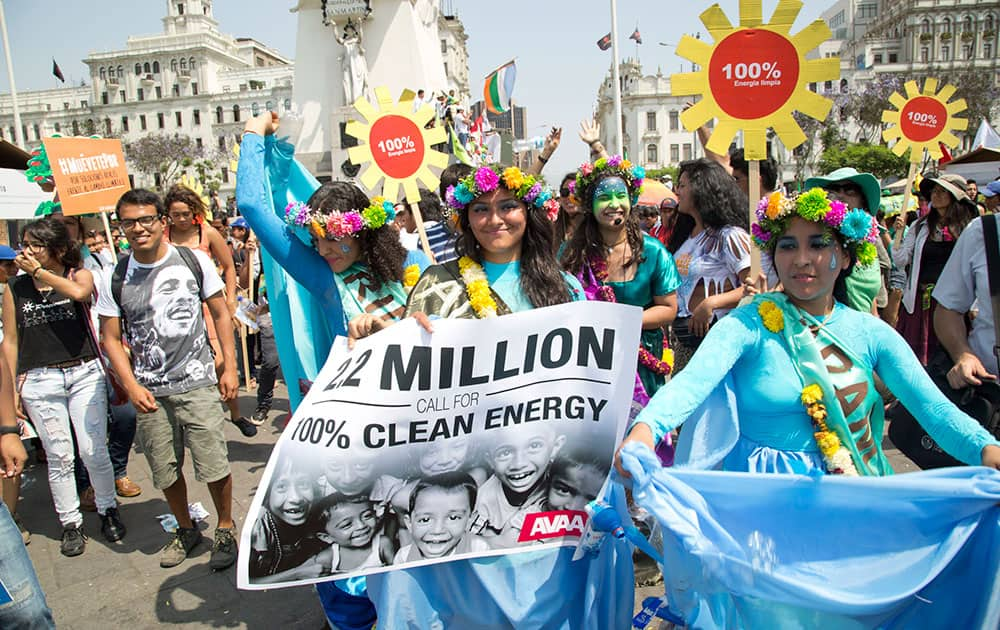 Protestors at the People's Climate March in Lima, Peru call for the ministers at the UN Climate talks to agree to a global shift to 100 per cent clean energy by 2050.