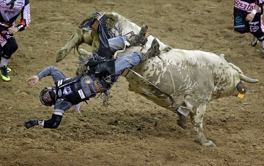 Trey Benton III gets bucked off by bull Cajun Smurf during the seventh go-round of the National Finals Rodeo, in Las Vegas.