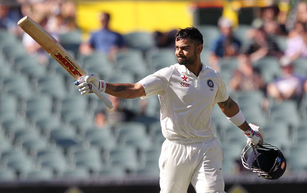 India's Virat Kohli raises his bat after making 100 runs against Australia during the third day of their cricket test match in Adelaide, Australia.