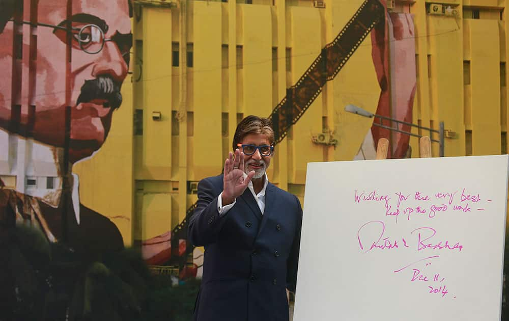 Bollywood superstar Amitabh Bachchan waves to the media as he unveils a mural of renowned Indian film producer and director Dadasaheb Phalke, on a building in Mumbai, India.