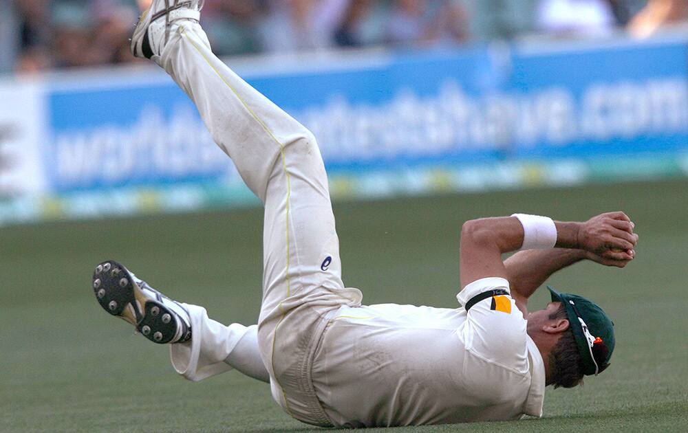 Australia's Ryan Harris catches out India's Virat Kohli for 115 runs during the third day of their cricket test match in Adelaide, Australia.