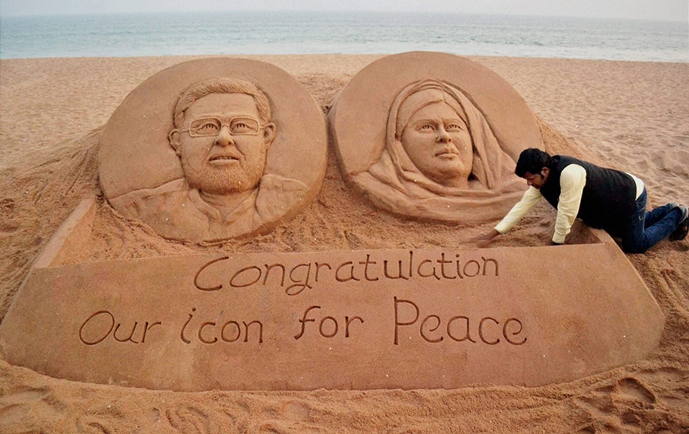 Sand artist Sudarshan Pattnaik gives finshing touches to a sand sculpture of Nobel Peace Prize winners, Kailash Satyarthi and Malala Yousafzai in Puri.