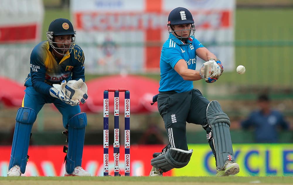 England's batsman Joe Root plays a shot as Sri Lankan wicketkeeper Kumar Sangakkara watches during the fifth one day international cricket match between Sri Lanka and England in Pallekele, Sri Lanka.