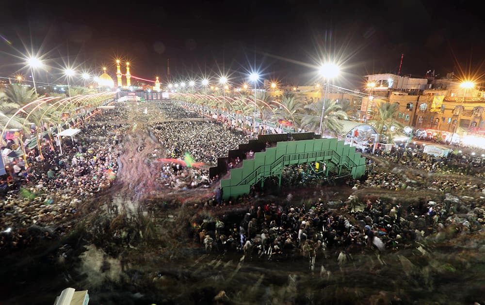 Shiite faithful pilgrims gather between, the holy shrine of Imam Hussein and the holy shrine of Imam Abbas, in the background, during the preparations for the Muslim festival of Arbaeen in the Shiite holy city of Karbala, 50 miles (80 kilometers) south of Baghdad, Iraq.