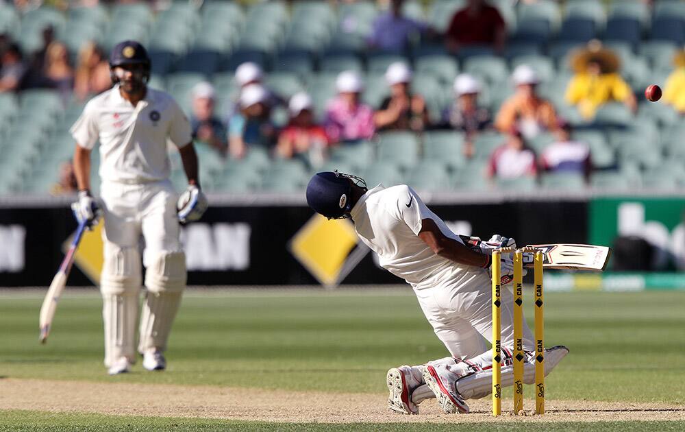 Rohit Sharma, leans back to avoid a high delivery from Australia's Mitchell Johnson as teammate Wriddhiman Saha watches during the third day of their cricket test match in Adelaide, Australia.
