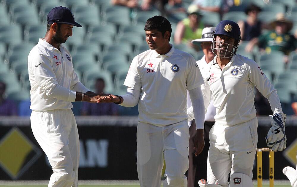 Karan Sharma, celebrates taking the wicket of Australia's David Warner, during the fourth day of their cricket test match in Adelaide.