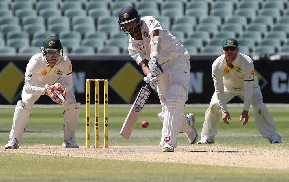 Murali Vijay plays a shot as Australia's Brad Haddin and David Warner, look on during the final day of their cricket test match in Adelaide, Australia.