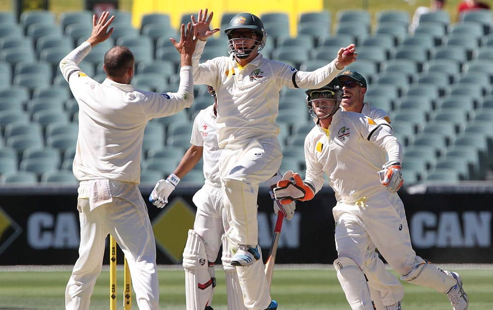 Australia's Chris Rogers leaps in the air to celebrate with teammate Nathan Lyon after catching out India's Ajinkya Rahane for no score during the final day of their cricket test match in Adelaide, Australia.