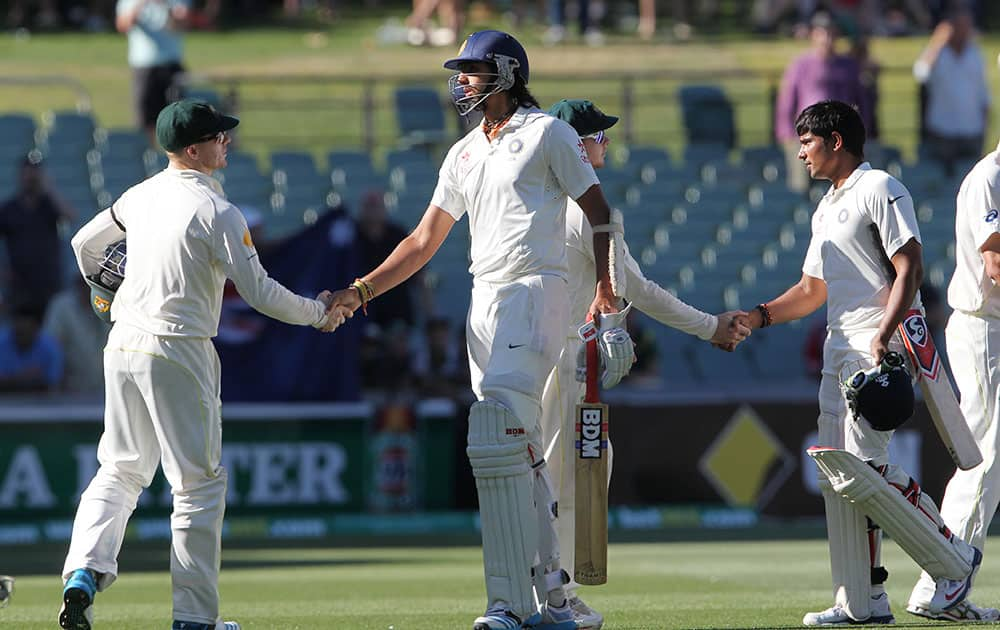 Ishant Sharma and Karn Sharma, congratulate Australian players Chris Rogers and Steven Smith after their 48 run loss on the final day of their cricket test match in Adelaide.