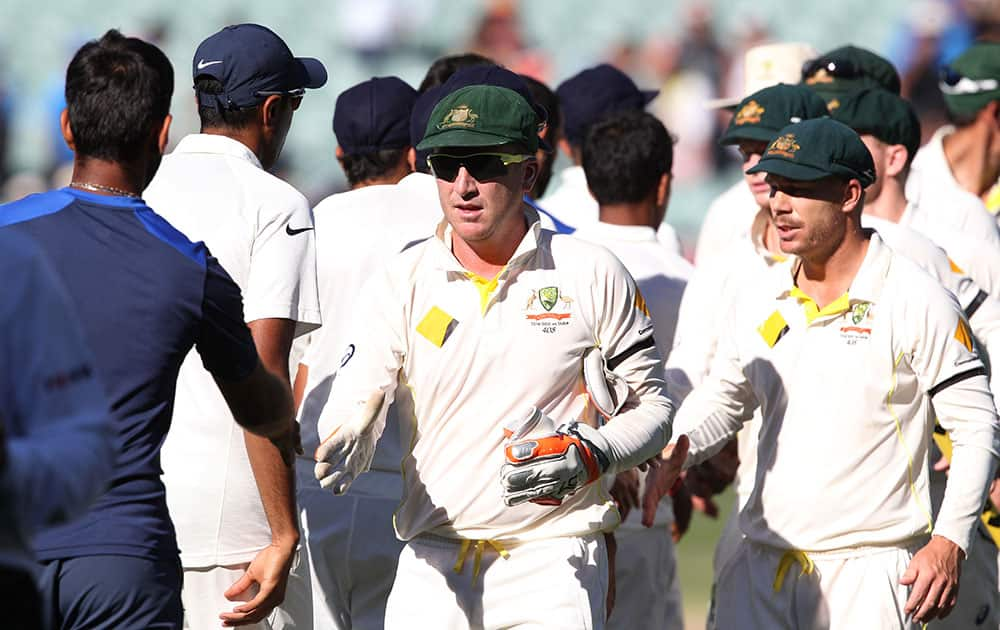 Australia's Brad Haddin and teammate David Warner, shake hands with the Indian players following their 48 run win on the final day of their cricket test match in Adelaide.